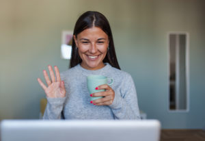 Woman waving during a video chat