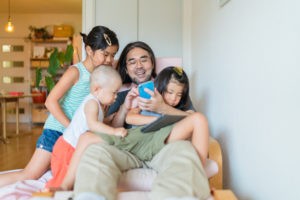 A modern father is taking care of his children at home.